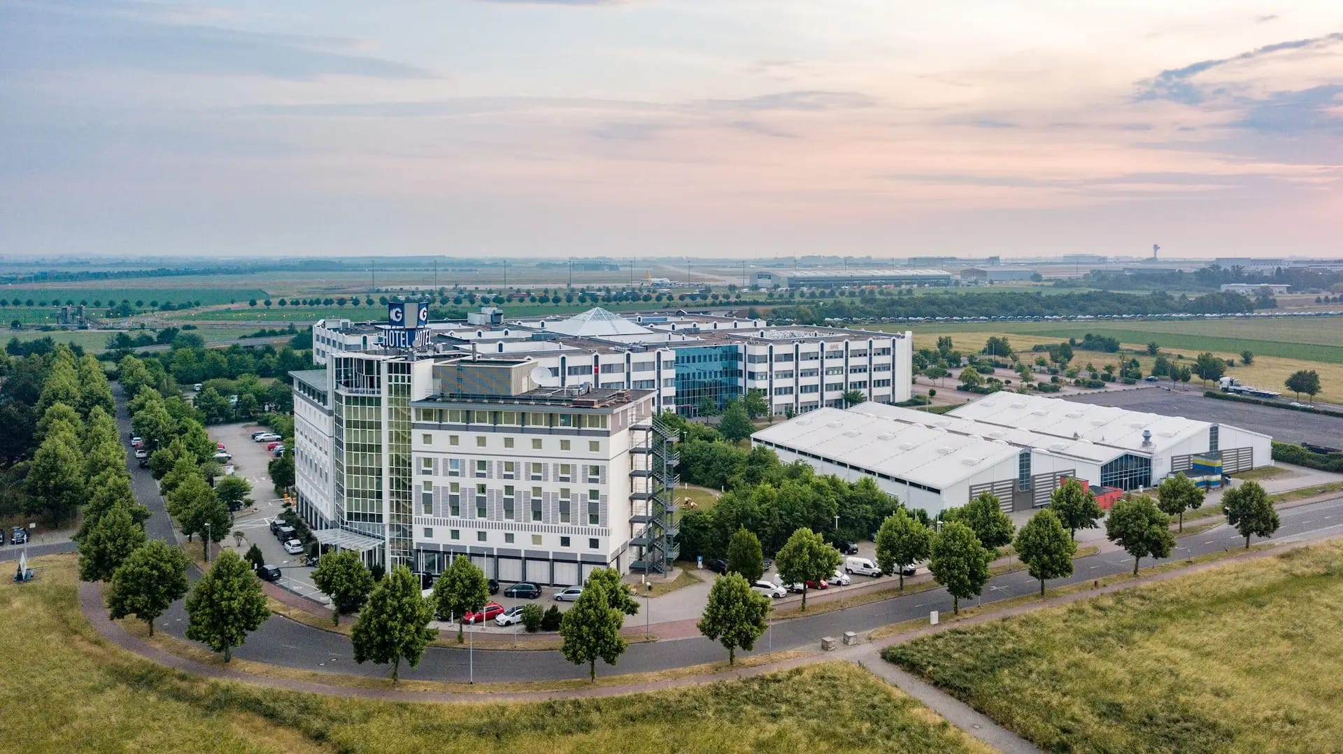 Luftbild vom gesamten Gebäudekomplex mit Messehalle, Eventhalle, Hotel und Außenanlage.