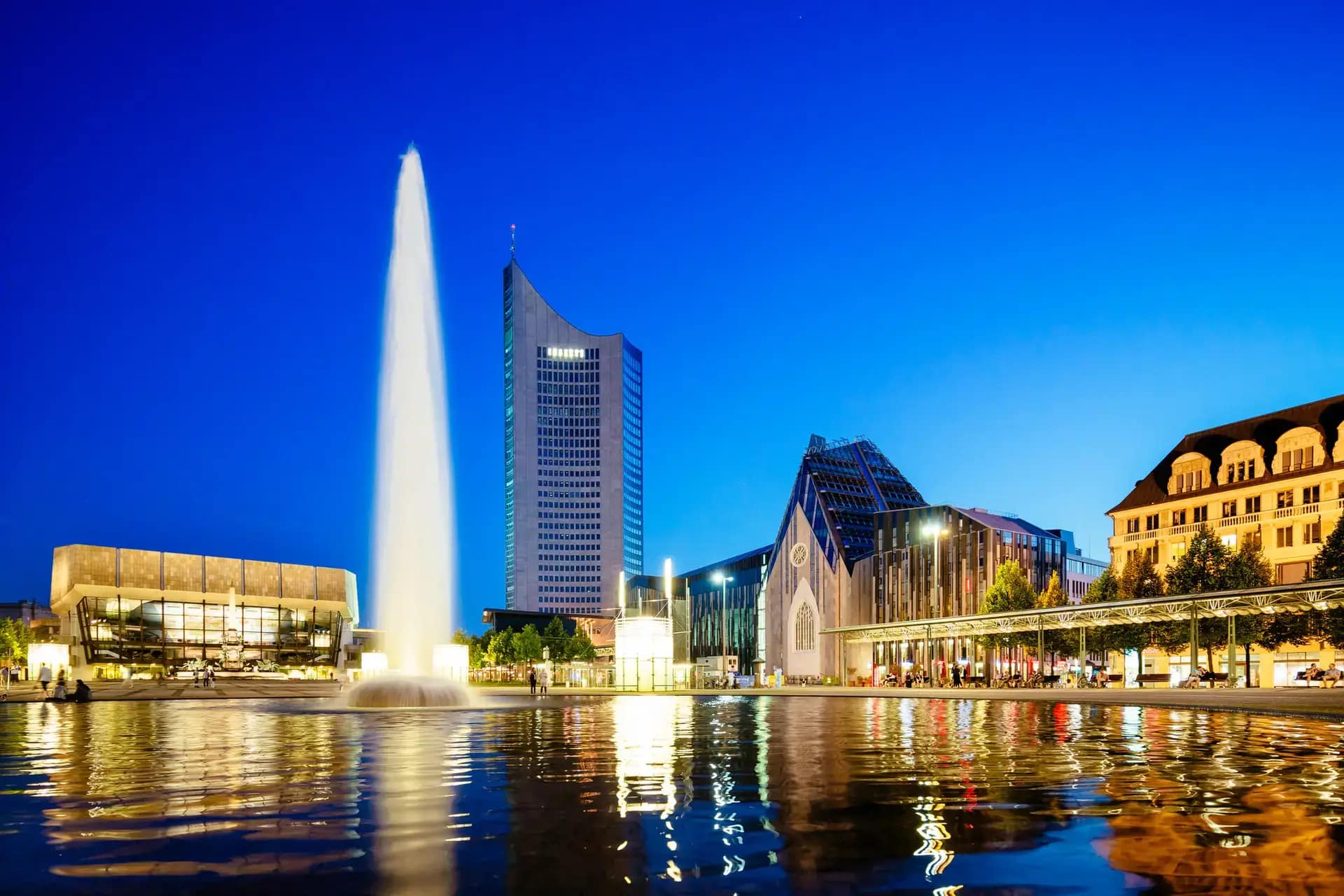 Fontäne auf dem Augustusplatz in Leipzig bei Nacht mit umliegenden Gebäuden aufgenommen mit Veranstaltungstechnik